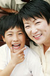 A boy and his mother smiling at the camera