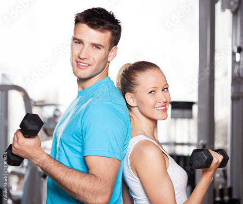Photo: Couple working out with dumbbells Couple working out with dumbbells