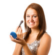 Teenage girl applying makeup or cosmetics isolated on white