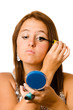 Teenage girl applying makeup or cosmetics isolated on white