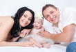 A happy family on white bed in the bedroom