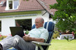 Retired man working outdoors on a laptop