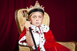 little boy dressed ad a king on red velvet background