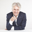 Foto: Successful mature businessman looking at camera at work in offi Successful mature businessman looking at camera at work in offi