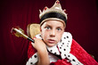 Foto: little boy dressed ad a king on red velvet background little boy dressed ad a king on red velvet background