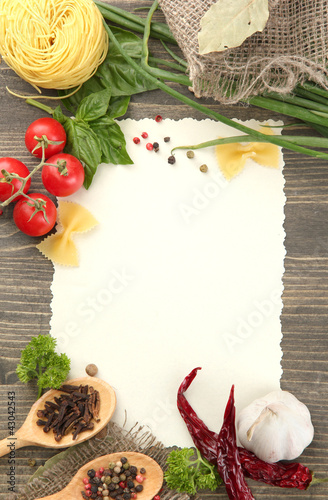Photo: paper for recipes vegetables, and spices on wooden table paper for recipes vegetables, and spices on wooden table