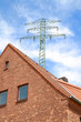 Hochspannungsmast über Haus