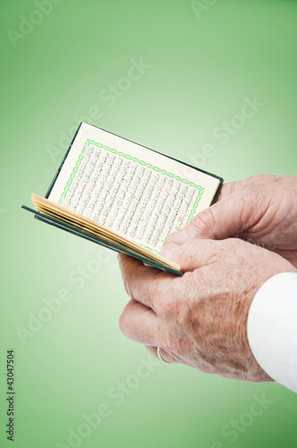 Photo: Hand with Pocket Quran Hand with Pocket Quran