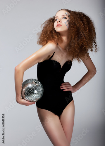 Photo: Sexy redhead female in black body with brilliant mirror ball Sexy redhead female in black body with brilliant mirror ball