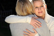 A woman and her daughter hugging.