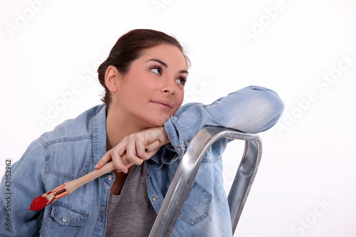 Photo: Dreamy woman taking a break from painting Dreamy woman taking a break from painting