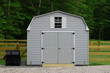 A nice new storage shed outside of a fenced in  back yard