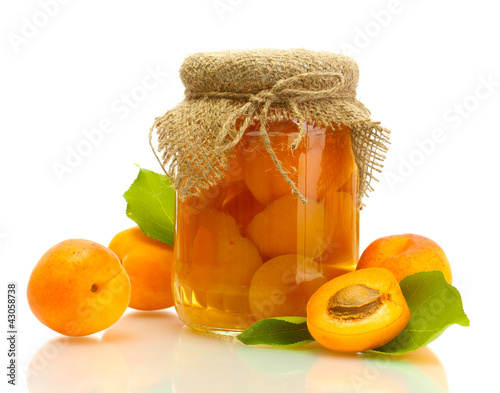 Photo: canned apricots in a jar and sweet apricots isolated on white canned apricots in a jar and sweet apricots isolated on white