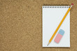 Photo: Pencil with eraser and notebook on cork Pencil with eraser and notebook on cork