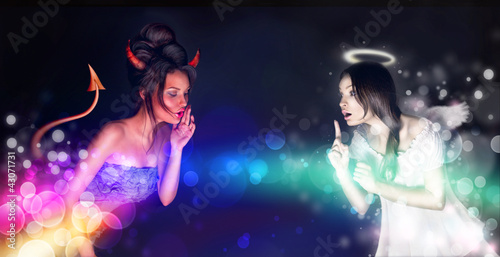 Photo: Portrait of angel and devil girls and copyspace between them. Portrait of angel and devil girls and copyspace between them.