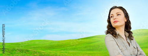 Photo: Pretty woman standing at beautiful countryside background. Natur Pretty woman standing at beautiful countryside background. Natur