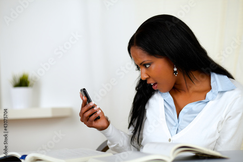 Photo: Beautiful girl reading a message on cellphone Beautiful girl reading a message on cellphone