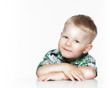 Photo: Portrait of a cute little boy smiling while sitting at table, Portrait of a cute little boy smiling while sitting at table,