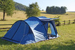 Blue tent campsites planted amidst the mountain meadow Green