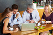 Foto: Geschäftsleute schauen auf Laptop in Café Geschäftsleute schauen auf Laptop in Café
