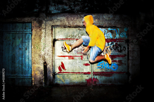 Photo: Young man jumping on grunge graffiti wall Young man jumping on grunge graffiti wall