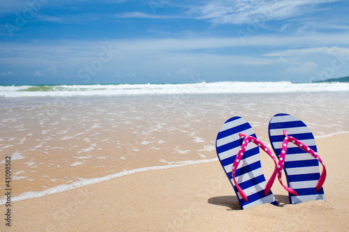 Photo: Colorful flipflop pair on sea beach Colorful flipflop pair on sea beach