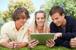 Photo: Three students using a touch pad Three students using a touch pad