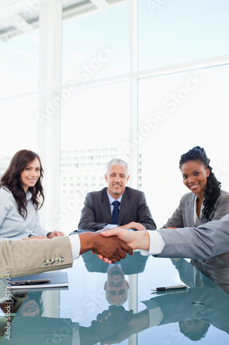 Photo: Handshake between two employees during a meeting Handshake between two employees during a meeting