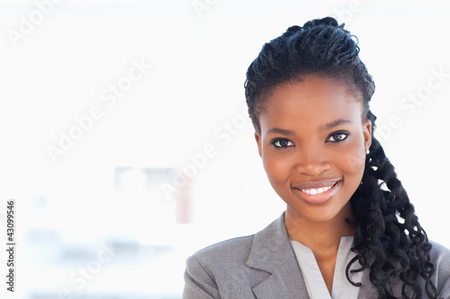 Photo: Young employee standing upright in front of a bright window whil Young employee standing upright in front of a bright window whil