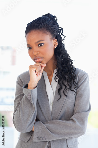 Foto: Businesswoman looking towards the side with her hand on her chin Businesswoman looking towards the side with her hand on her chin