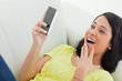 Close-up of a surprised Latino woman  looking her smartphone