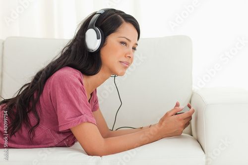 Photo: Young Latino listening music with a blank stare Young Latino listening music with a blank stare