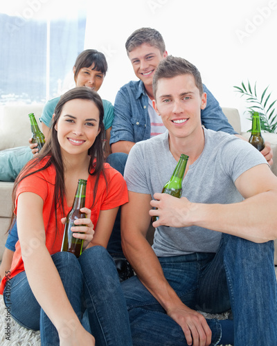 Photo: Two people sitting on the couch with the other two sitting on th Two people sitting on the couch with the other two sitting on th