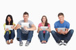 A group of people sitting beside each other with tablets while l