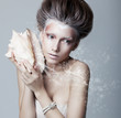 Beautiful girl with seashell in her hands. Flowing music
