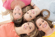 Four girls smiling as they lie on the floor together