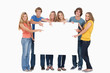Smiling group of people with a blank space as they point to it