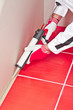 Photo: worker applies silicone sealant on corner wall tiles worker applies silicone sealant on corner wall tiles