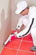 Photo: worker in white clouts lays silicone sealant corner wall floor worker in white clouts lays silicone sealant corner wall floor