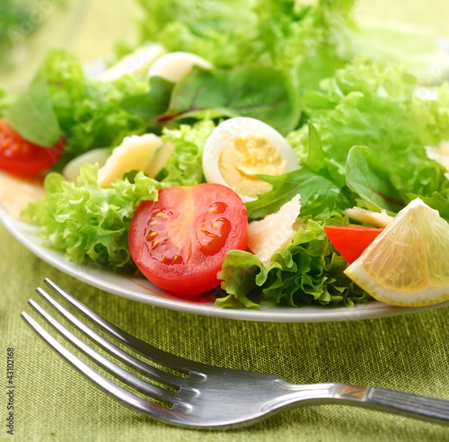 Foto: Fresh salad with tomato and quail eggs. Fresh salad with tomato and quail eggs.
