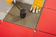Photo: Worker with rubber hammer install glass tiles with tile adhesive Worker with rubber hammer install glass tiles with tile adhesive
