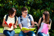 Three students on a bench in the park
