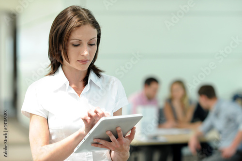 Foto: Office worker using electronic tablet in on front of group Office worker using electronic tablet in on front of group
