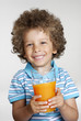 Foto: Niño sujetando un vaso de jugo de naranja,bebiendo jugo. Niño sujetando un vaso de jugo de naranja,bebiendo jugo.
