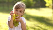 Girl eagerly eating grapes outdoors
