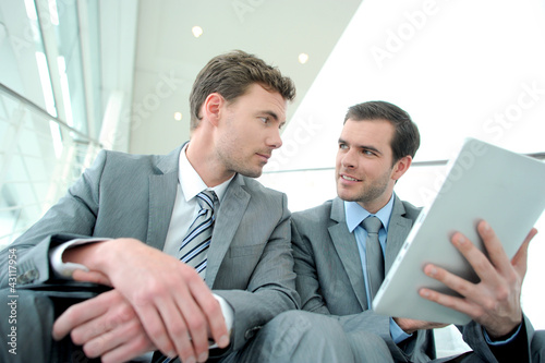 Photo: Business meeting in stairs with electronic tablet Business meeting in stairs with electronic tablet