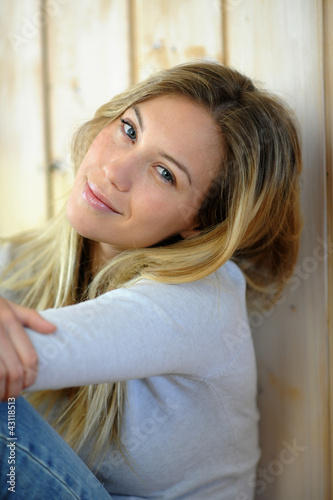 Photo: Portrait of beautiful blond woman sitting on the floor Portrait of beautiful blond woman sitting on the floor