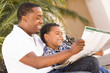 Foto: Mixed Race Father and Son Reading Park Brochure Outside Mixed Race Father and Son Reading Park Brochure Outside