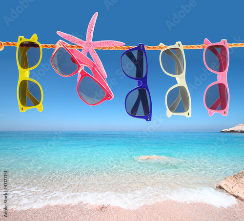 Foto: Collection of sunglasses on the beach Collection of sunglasses on the beach