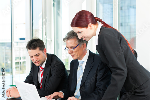 Photo: Business people - team meeting in an office Business people - team meeting in an office